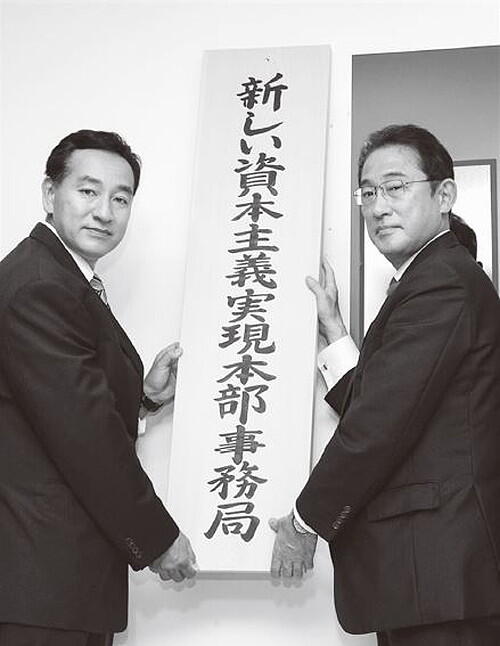 新しい資本主義実現本部事務局を掲げる岸田総理と山際大臣（出典：内閣官房新しい資本主義事務局） 